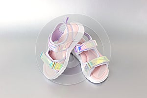 Stylish holographic sandals for kids on grey background. Shiny fashion summer shoes