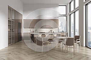 Stylish home kitchen interior with bar island and eating table, panoramic window