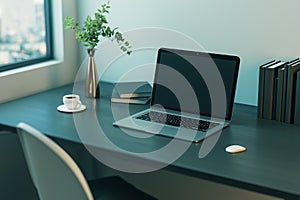 Stylish home workspace with dark blank modern laptop screen for advertising logo or web design on wooden table with coffee cup,