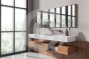 Stylish hotel bathroom interior with sink, accessories and window