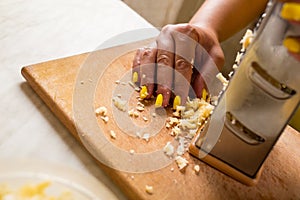 Stylish housewife. Prepare cheese for pizza. Grate parmesan at home