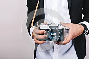 Stylish image of retro camera in hands of handsome guy in suit. Leisure, journalist, photograph, hobbies, having fun.