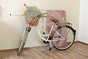 Stylish interior of light spacious room with modern bicycle and lights garland.