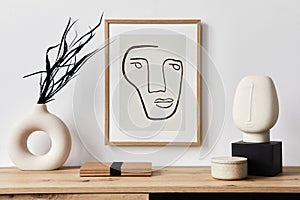 Stylish interior of living room with mock up poster frame, wooden commode, book, black leaf in ceramic vase.