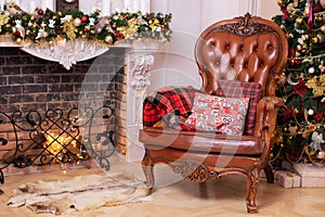 Stylish interior of room with Christmas fir tree and brown armchair. Beautiful cozy decorated living room for Christmas with firep