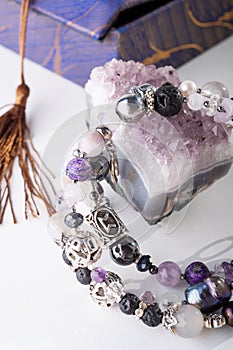 Stylish jewelry bracelet with semiprecious and amethyst  crystal around  white background. hobby and fashion concept. close up photo