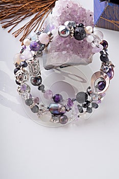 Stylish jewelry bracelet with semiprecious and amethyst crystal at white background. hobby and fashion concept photo