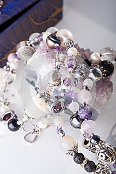 Stylish jewelry bracelets with natural semiprecious and amethyst  crystal around  white background. hobby and fashion concept. photo