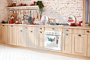 Stylish kitchen interior design. Modern wooden furniture and steel oven, pots, plates. front view of a kitchen table in kitchen.