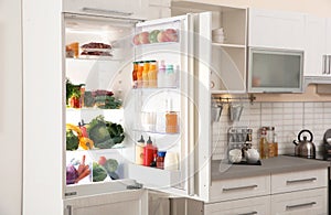 Stylish kitchen interior with refrigerator full