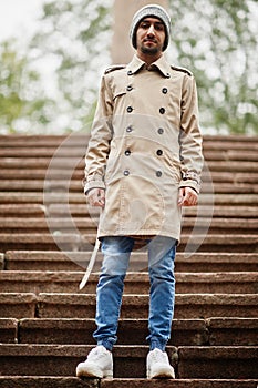 Stylish kuwaiti man at trench coat and hat