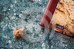 A stylish leather photo book and a seashell lie on a tabletop