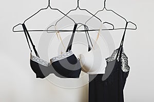 Stylish lingerie. Variety of bra and nightie hanging on a hanger. Set of female underwear. Advertise or sale concept