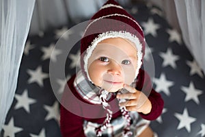 Stylish little toddler boy, playing around christmas decoration