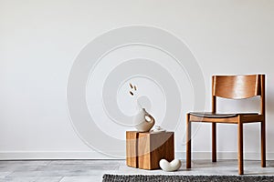 Stylish living room interior composition with creative design vintage chair, wooden cube and elegant personal accessories.