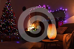 Stylish living room interior with lamp and Christmas lights