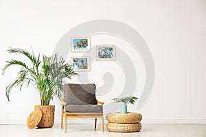 Stylish living room interior with wooden armchair and plants near white wall