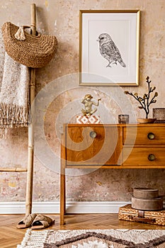 Stylish living room with vintage commode, gold mock up photo frame, wooden ladder, bag, plaid, decoration, grunge wall.