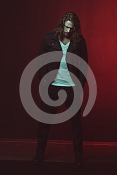 Stylish long haired man posing in studio