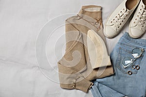 Stylish look with cashmere sweater, flat lay. Women`s clothes and accessories on fabric
