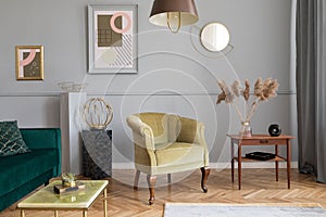 Stylish and luxury living room interior with elegant green armchair, furniture, design accessories, gold mirror.