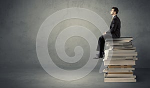 Stylish male seated on books