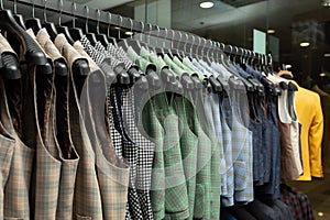 Stylish male vests on hangers in the row. a lot of beatiful vests in a row
