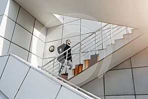 Stylish man in back coat going upstairs. Minimalizm style.