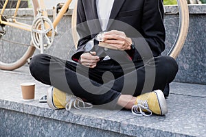 Stylish man in black suit and casual shoes cleaning his reading