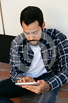 Stylish man browsing websites while using his tablet, outdoors