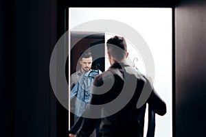 Stylish Man Checking Himself in the Mirror Trying on Clothes