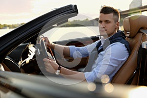Stylish man driving luxury convertible car
