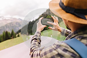 Stylish man has lost his way and looking for new route on map in the phone walking down the road. Outdoor portrait from