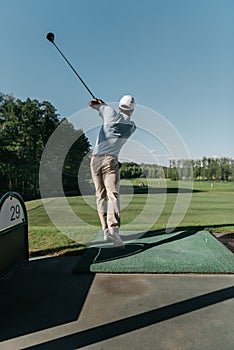 Stylish man playing golf alone at golf course