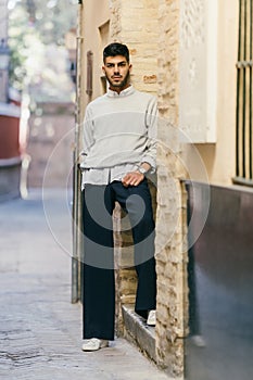 Stylish man posing while looking at the camera with a cocky expression outdoors