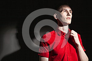 Stylish man in red shirt in dark studio