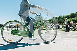 Stylish man rides a beautiful city park bike ride. Walk on a bike. Active rest. Walking bicycle