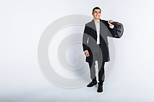 Stylish man in Studio on a white background, with a bag for travel, isolated, background, man goes on a journey