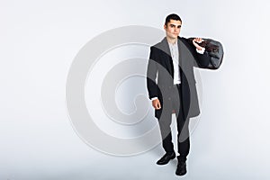 Stylish man in Studio on a white background, with a bag for travel, isolated, background, man goes on a journey