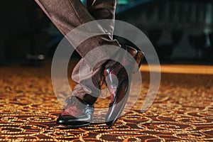 Stylish man in textured brown suit pants and brown and black brogue shoes