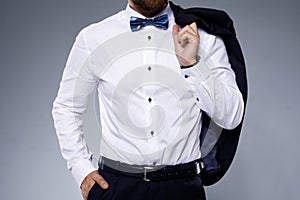 Stylish man wearing bow tie on gray background