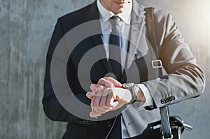 Stylish man wearing suit looks at watch