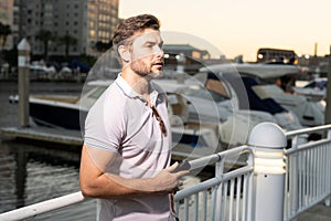 Stylish man wearing sunglasses and shirt. Handsome man outdoors portrait. Portrait of stylish male model outdoor