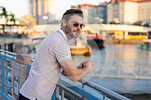 Stylish man wearing sunglasses and shirt. Handsome man outdoors portrait. Portrait of stylish male model outdoor