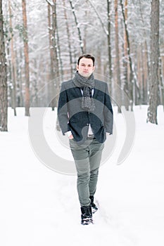 Stylish man in winter scenery. Young groom outside in winter