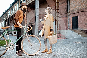 Stylish man and woman with retro bicycle outdoors