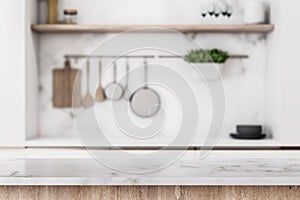 Stylish marble tabletop on wooden platform with copyspace for your logo at blurry kitchen utensils and dishes on light wall