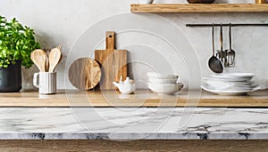 Stylish marble tabletop on wooden platform with copyspace for your logo at blurry kitchen utensils and dishes on light wall