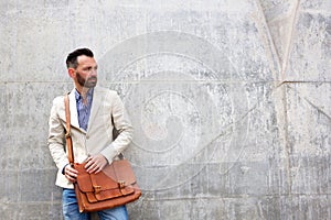 Stylish mature man standing against wall