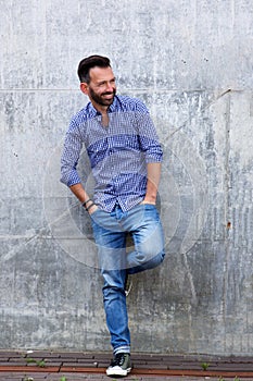 Stylish mature man standing against wall